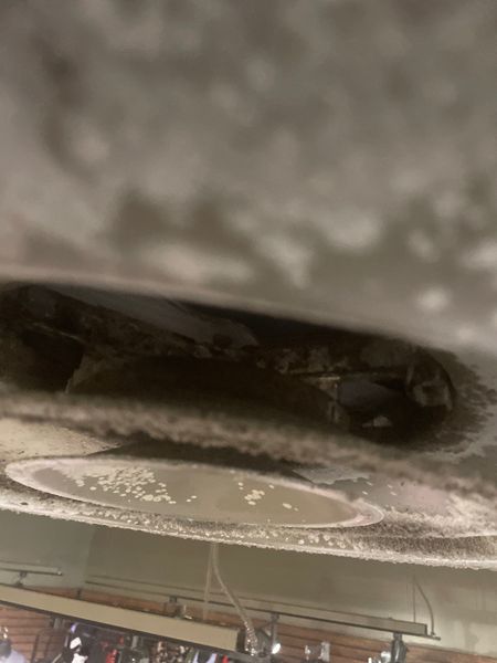 Dirty commercial ceiling vent with heavy dust buildup requiring duct cleaning