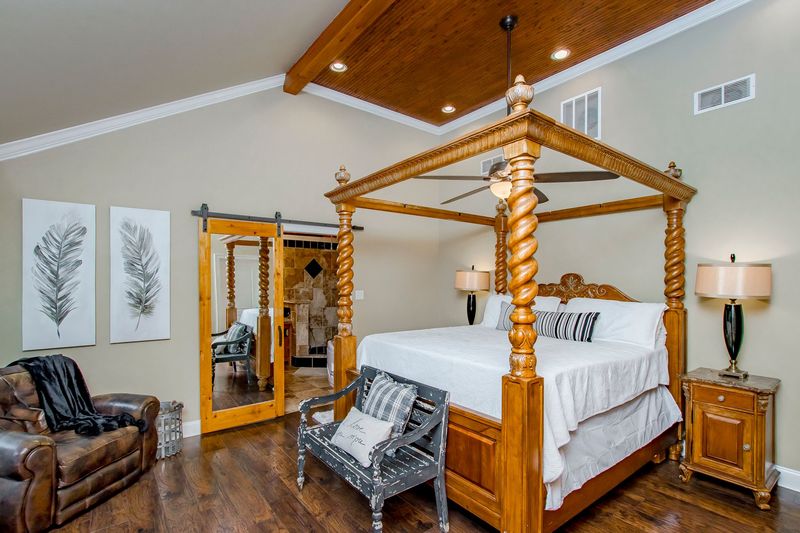 Stunning master bedroom restoration complete with vaulted wood ceiling and barn door