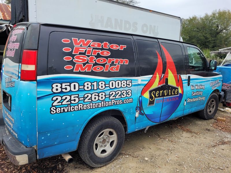 Service Restoration Pros branded van — Water Fire Storm Mold with company logo and phone numbers