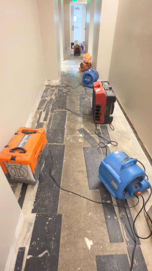 Commercial drying equipment in water damaged corridor — emergency water restoration